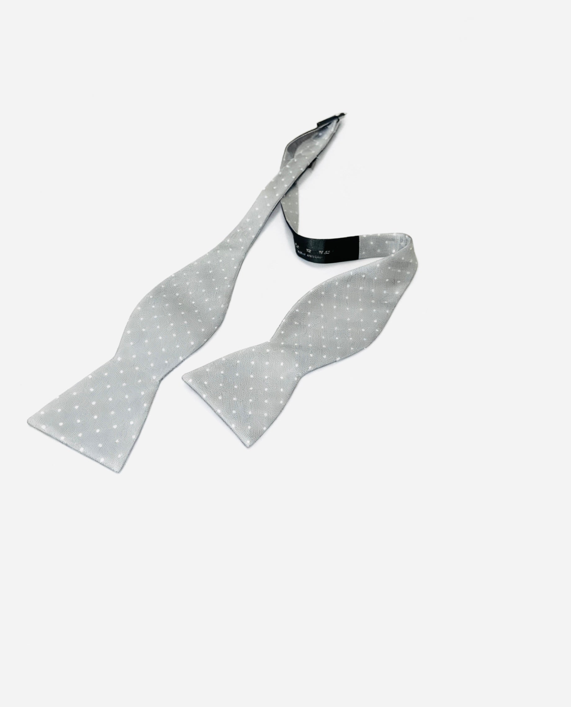 Gray bow tie with white polka dots on a white background