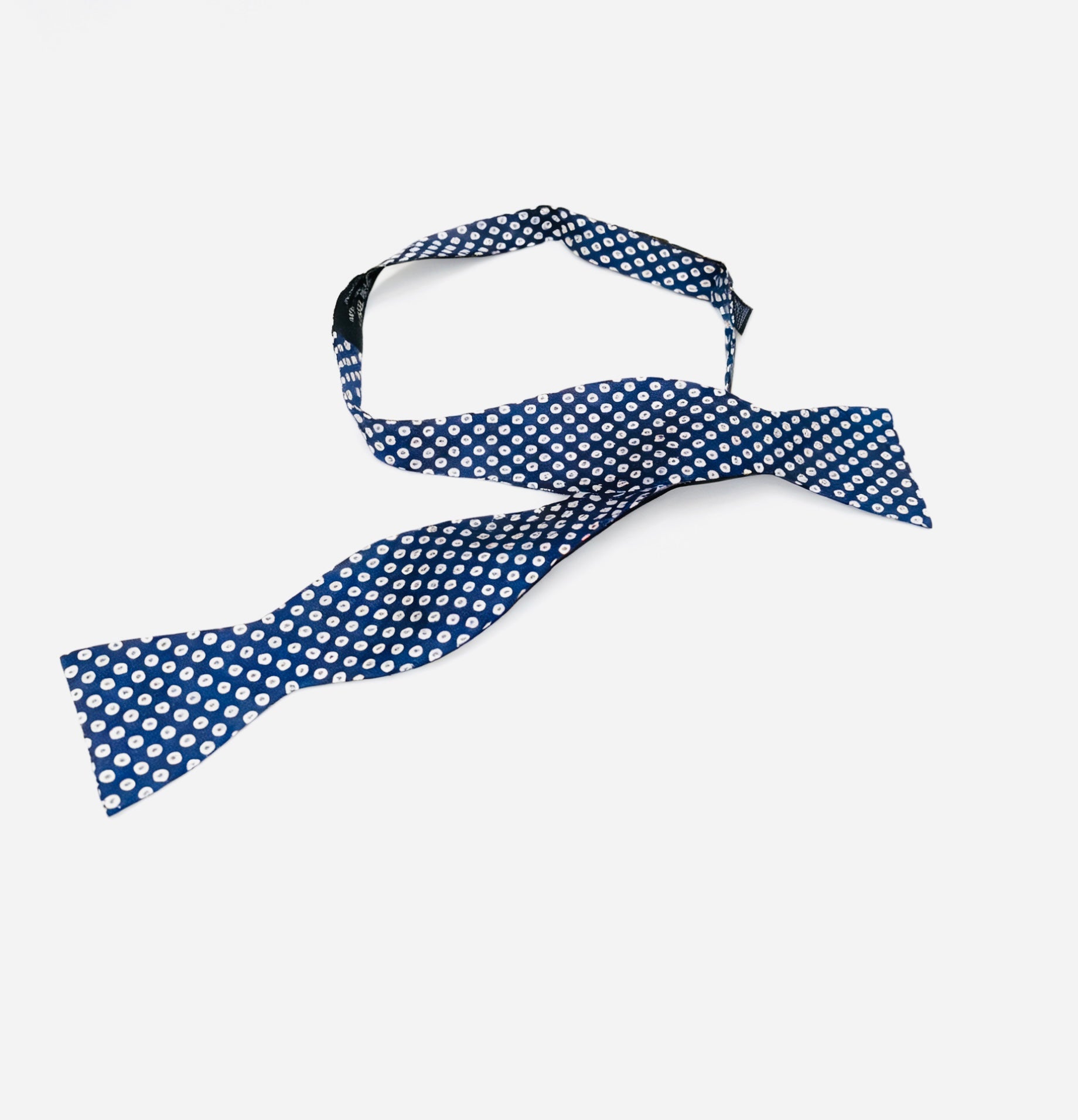 Blue polka dot bow tie on a white background