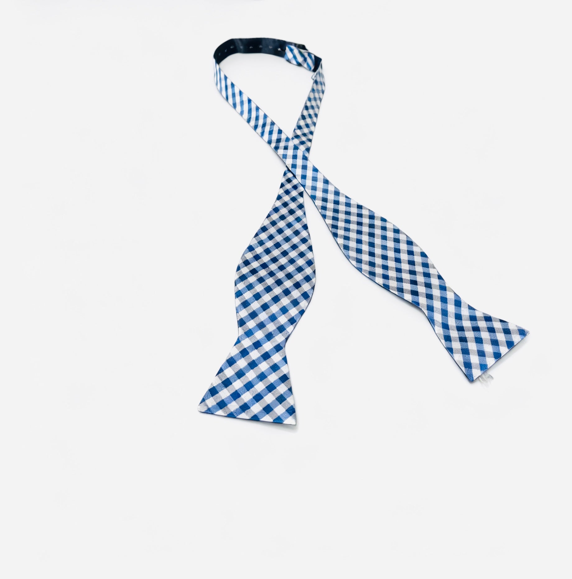 Blue and white checkered bow tie on a light gray background