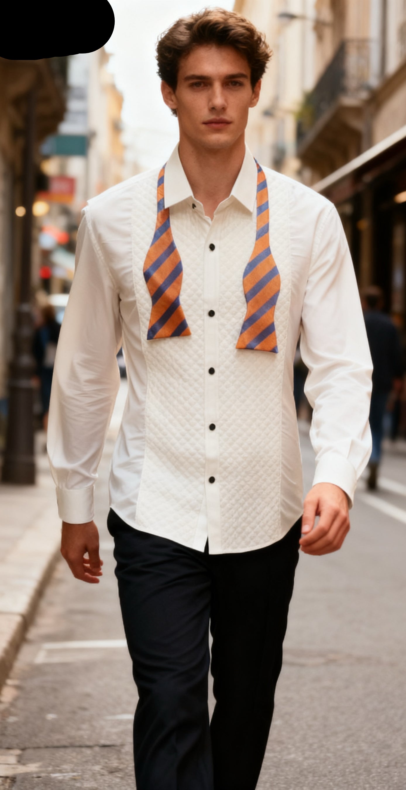Man wearing a white shirt with a patterned tie and black pants on a city street.